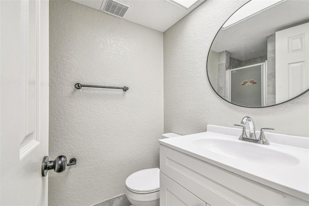 5111 Amulet Drive, Unit 104 New Port Richey, FL 34652 - Photo 25 of 74 a bathroom with a granite countertop toilet sink and mirror