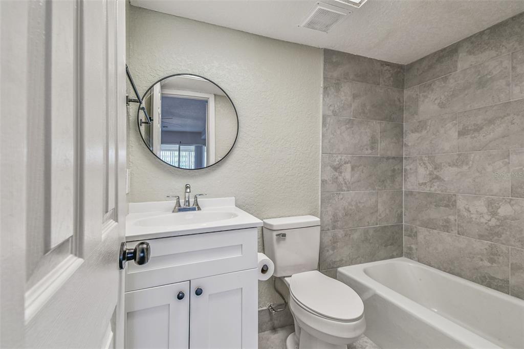 5111 Amulet Drive, Unit 104 New Port Richey, FL 34652 - Photo 37 of 74 a bathroom with a sink a toilet and a mirror