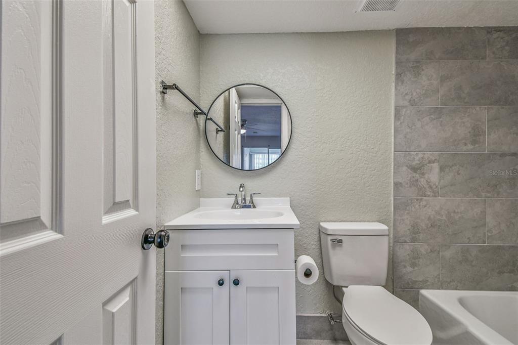 5111 Amulet Drive, Unit 104 New Port Richey, FL 34652 - Photo 38 of 74 a bathroom with a toilet a sink and mirror