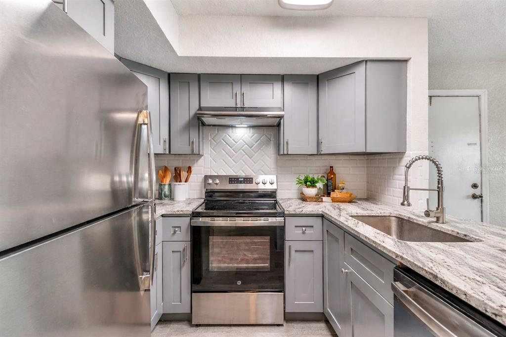 5111 Amulet Drive, Unit 104 New Port Richey, FL 34652 - Photo 4 of 74 a kitchen with a stove and a sink