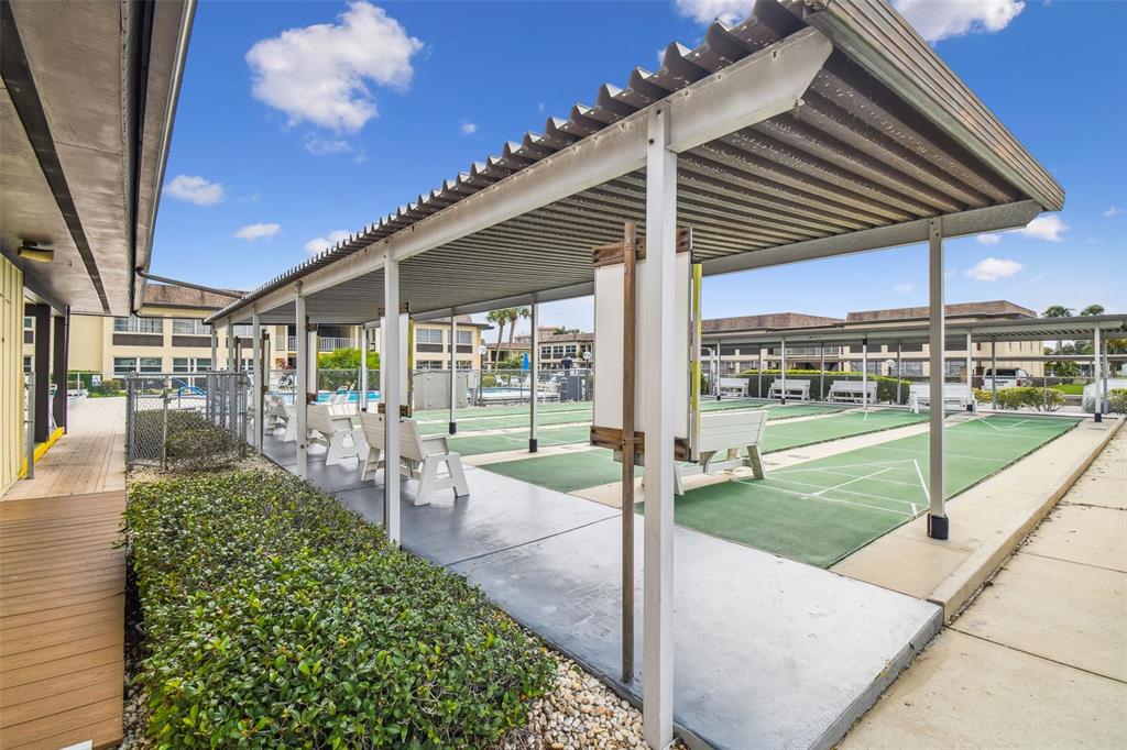 5111 Amulet Drive, Unit 104 New Port Richey, FL 34652 - Photo 60 of 74 a view of a patio with a table and chairs