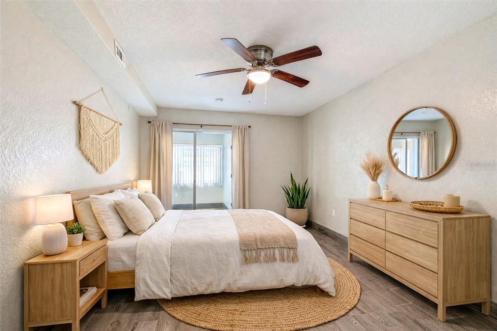 5111 Amulet Drive, Unit 104 New Port Richey, FL 34652 - Photo 6 of 74 a bedroom with a large bed and a chandelier