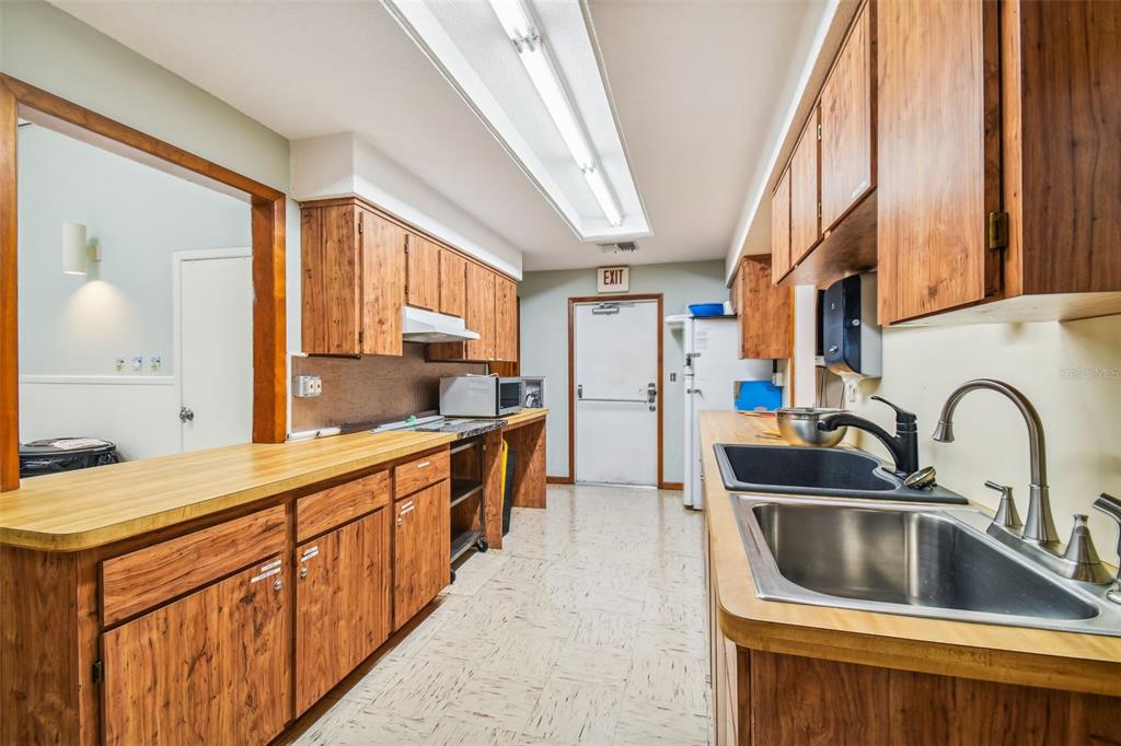 5111 Amulet Drive, Unit 104 New Port Richey, FL 34652 - Photo 67 of 74 a kitchen with stainless steel appliances a sink a counter top space and cabinets