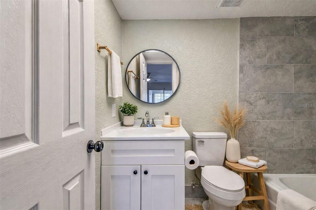5111 Amulet Drive, Unit 104 New Port Richey, FL 34652 - Photo 74 of 74 a bathroom with a toilet a sink and a mirror