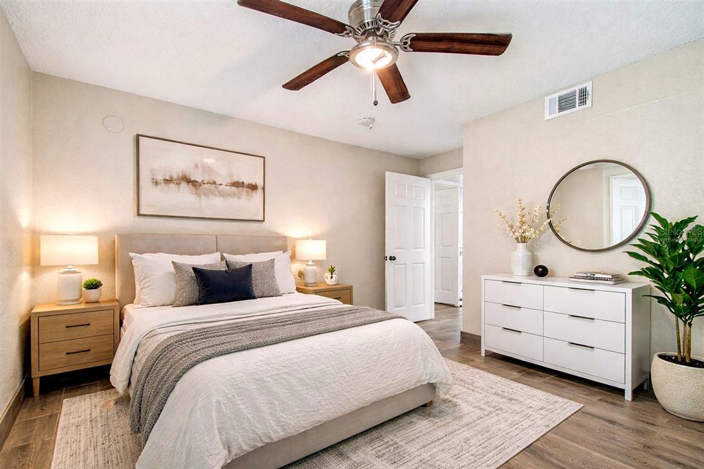 5111 Amulet Drive, Unit 104 New Port Richey, FL 34652 - Photo 9 of 74 a bedroom with bed and a chandelier