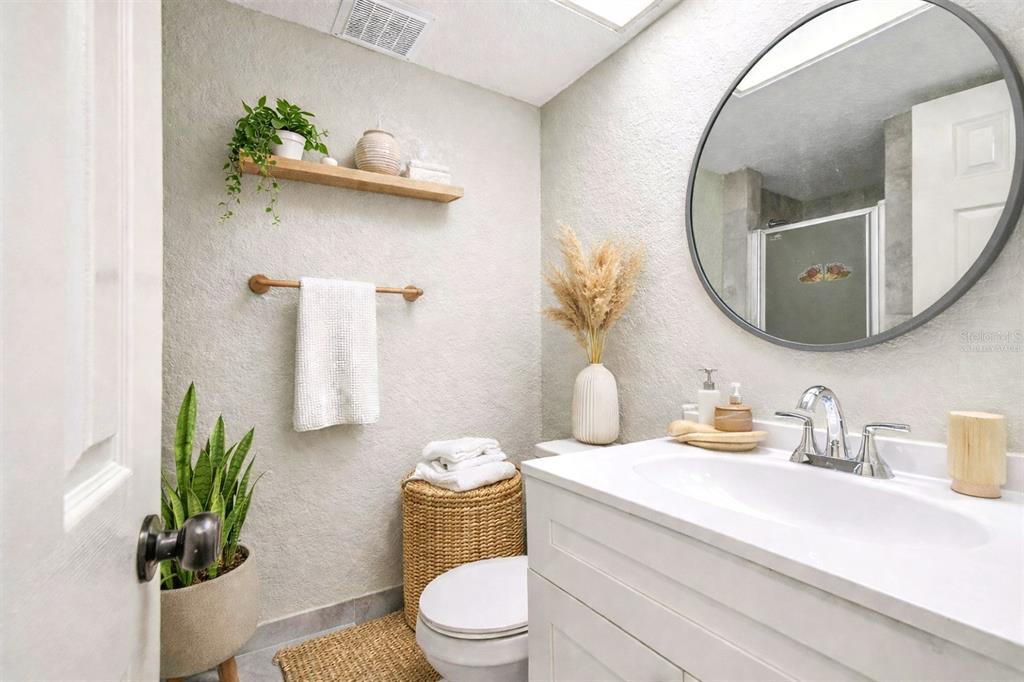 5111 Amulet Drive, Unit 104 New Port Richey, FL 34652 - Photo 10 of 74 a bathroom with a toilet sink and mirror