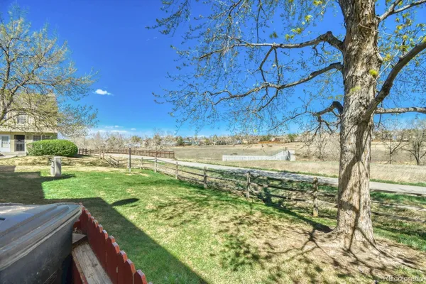 a view of a yard with wooden fence