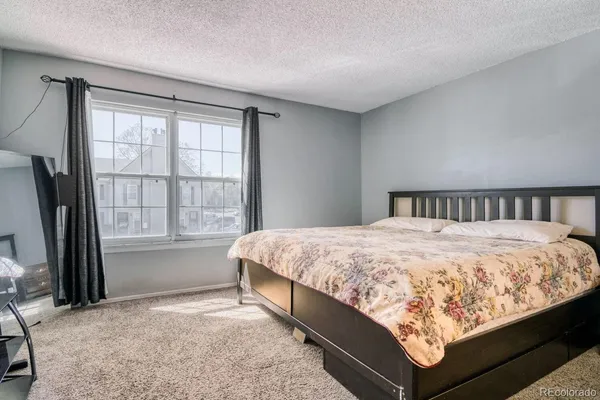 a large bed sitting in a bedroom next to a window
