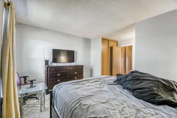 a bedroom with a bed and a flat screen tv