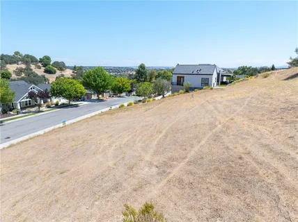 an aerial view of a house with a yard and mountain view in back