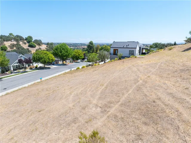 an aerial view of a house with a yard and mountain view in back