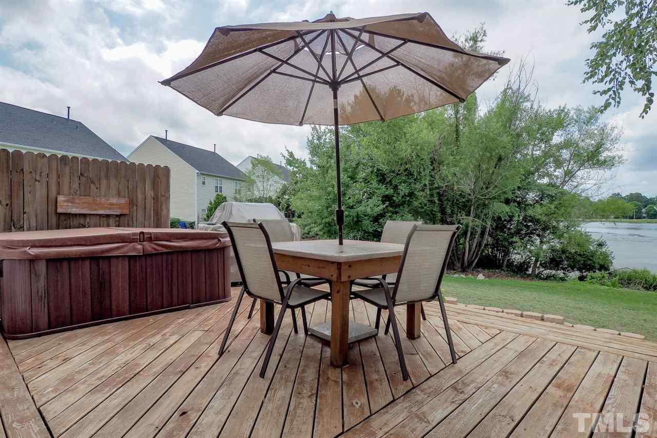 2341 Persimmon Ridge Drive Raleigh, NC 27604 - Photo 6 of 25 a view of a roof deck with table and chairs under an umbrella with wooden floor