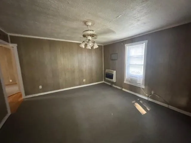 an empty room with windows and ceiling fan