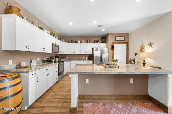 a kitchen with stainless steel appliances granite countertop a sink a stove and cabinets