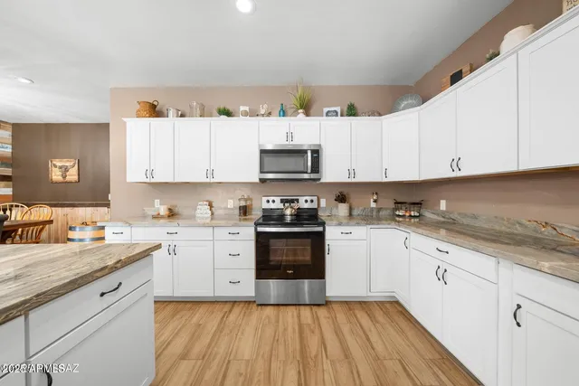 a kitchen with granite countertop white cabinets and white appliances