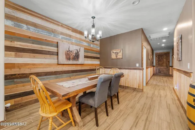 a dining room with wooden floor and a chandelier