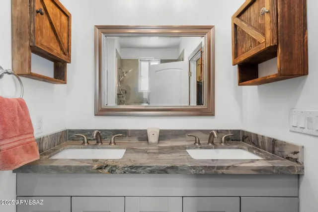 a bathroom with a granite countertop sink and a mirror