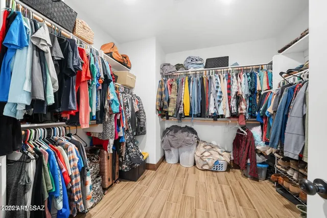 a view of walk in closet with clothes