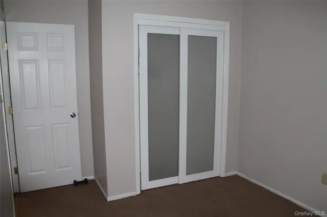 an empty room that has a wooden cupboard