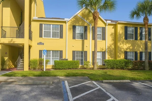 a view of a big house with a yard and plants