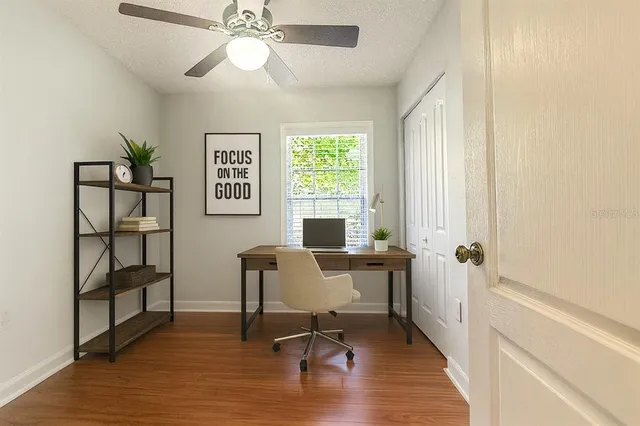 a view of a workspace with furniture and a window