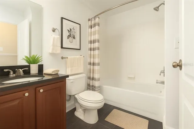 a bathroom with a granite countertop sink toilet a large mirror a shower and bathtub