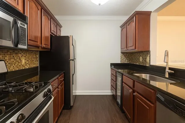 a kitchen with granite countertop a refrigerator stove and microwave