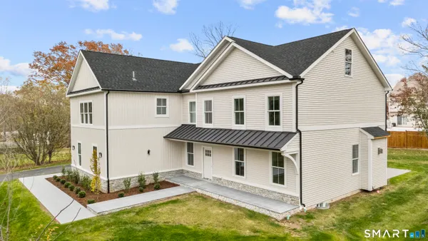 a view of a white house with large windows and yard