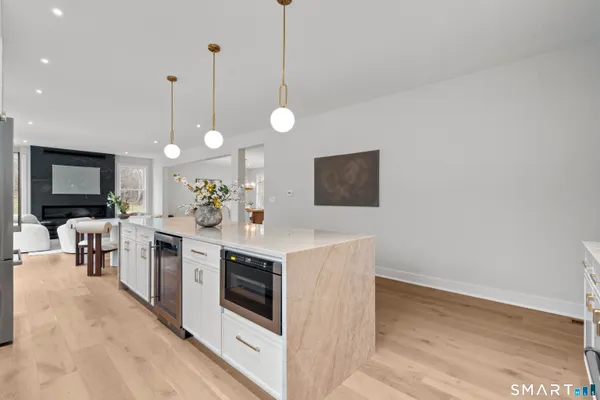 a view of a kitchen counter top space with stainless steel appliances a stove and a flat screen tv