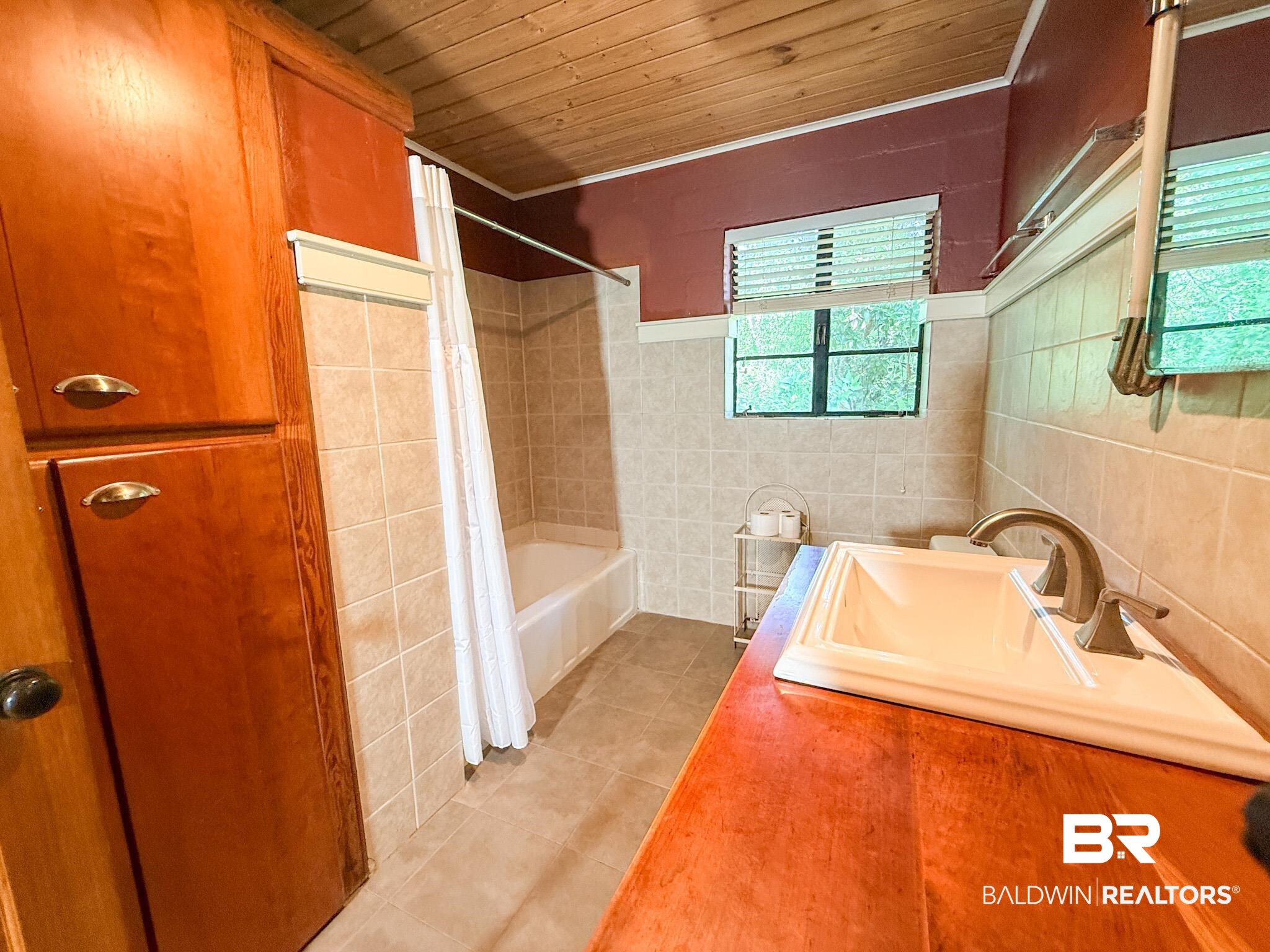 18711 Keller Road Foley, AL 36535 - Photo 20 of 38 Bathroom featuring a wood-finish countertop with an integrated sink, a tiled shower-tub combination, and a wood-paneled ceiling