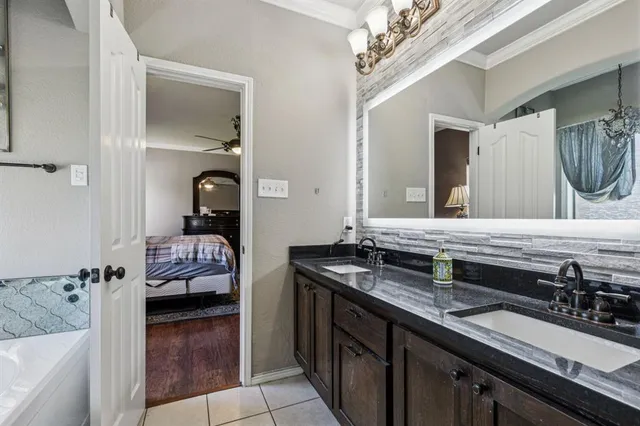 a en suite bathroom with a double vanity sink and a mirror
