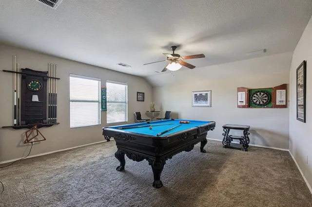 a room with furniture pool table and window