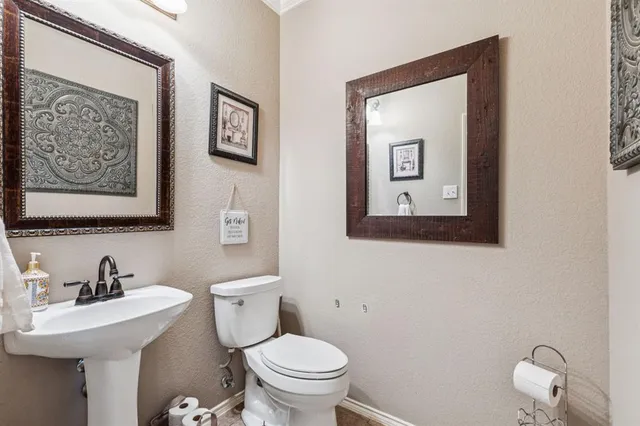 a bathroom with a toilet sink and mirror