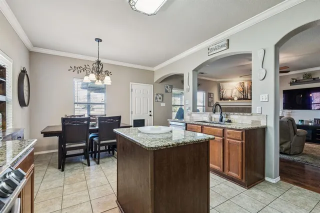 a kitchen with granite countertop sink table and chairs