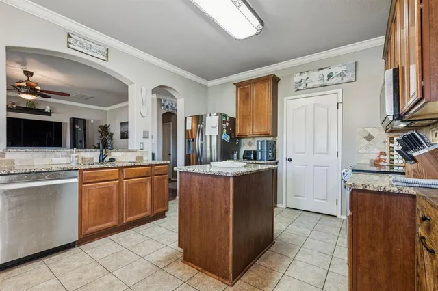 a large kitchen with stainless steel appliances granite countertop a sink and a cabinets