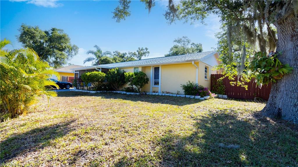 1230 Ramsdel Street Port Charlotte, FL 33952 - Photo 1 of 37 a view of a backyard with potted plants and large tree