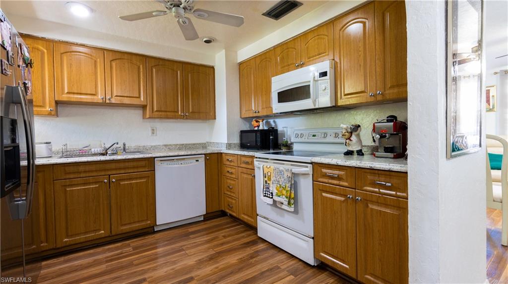 1230 Ramsdel Street Port Charlotte, FL 33952 - Photo 13 of 37 a kitchen with stainless steel appliances granite countertop a sink a stove cabinets and wooden floor