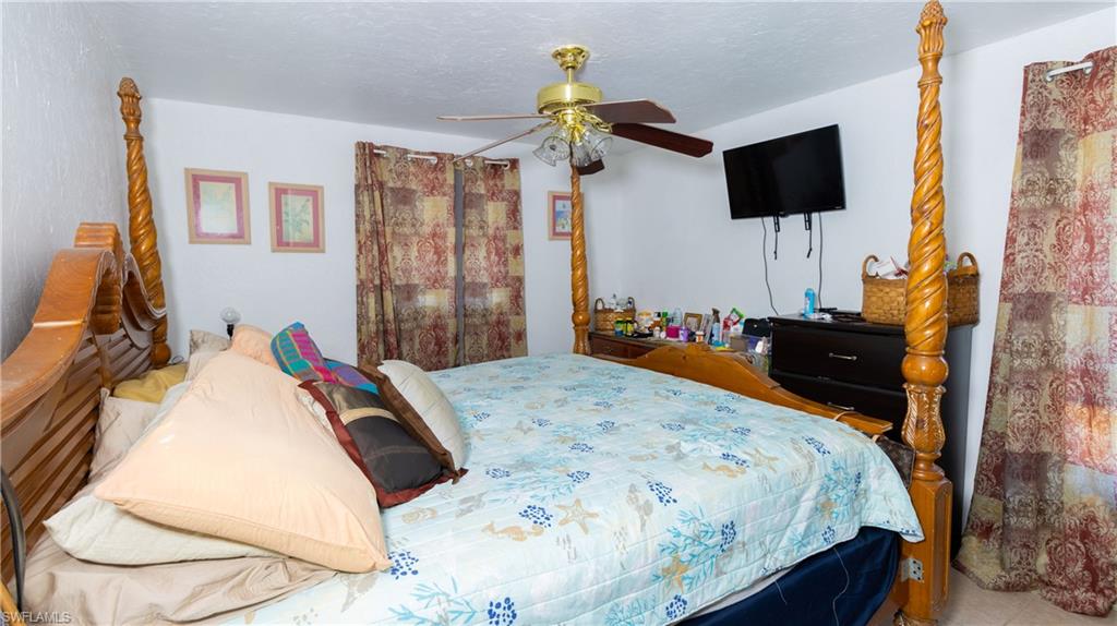 1230 Ramsdel Street Port Charlotte, FL 33952 - Photo 21 of 37 a bedroom with a bed and a flat screen tv