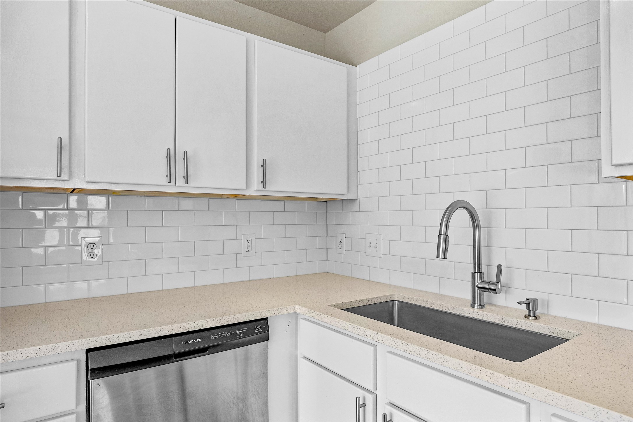 7541 Redrick Drive Austin, TX 78747 - Photo 18 of 40 Kitchen featuring decorative backsplash, dishwasher, white cabinetry, and a sink
