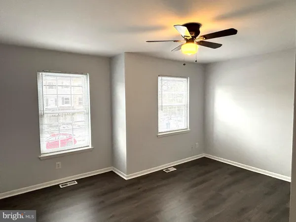 an empty room with wooden floor a ceiling fan and closet
