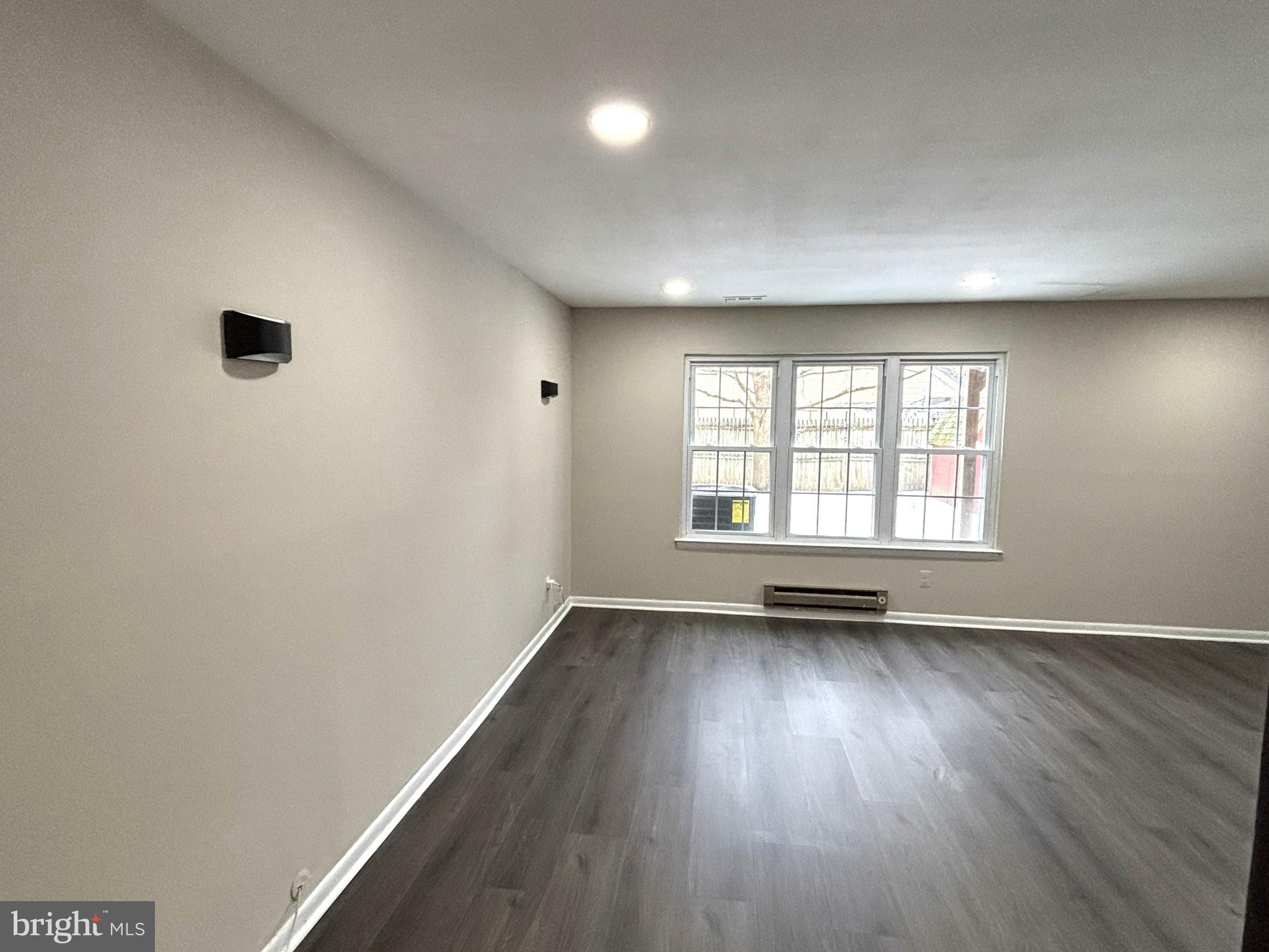 104 Chaucer Road, Unit A Mount Laurel, NJ 08054 - Photo 4 of 20 an empty room with wooden floor and windows