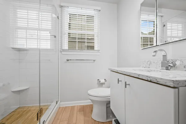 a bathroom with a granite countertop sink toilet and shower