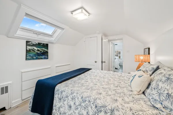 a bedroom with a bed and a painting on the wall