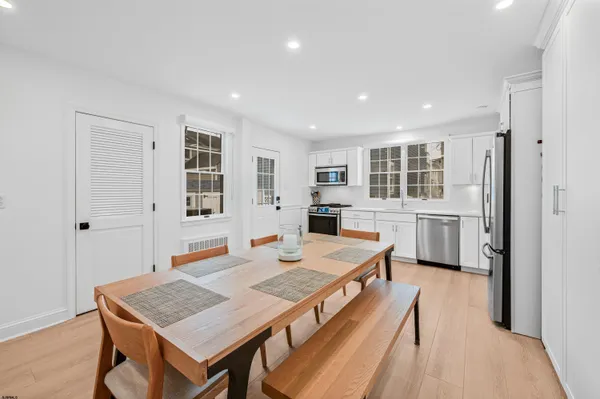 a living room with stainless steel appliances granite countertop furniture and wooden floor