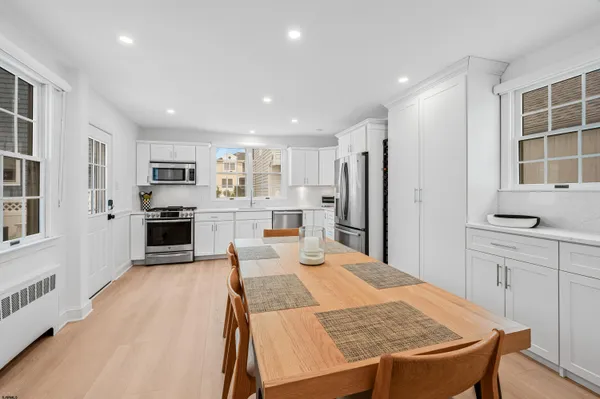 a large kitchen with kitchen island a stove a sink a refrigerator and cabinets