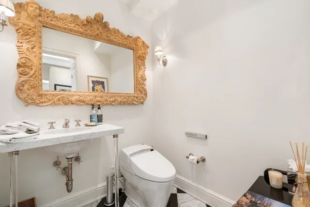 a bathroom with a toilet sink and mirror