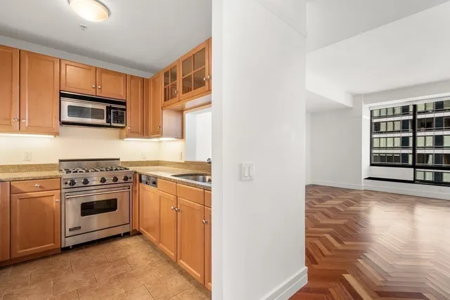 a kitchen with granite countertop white cabinets and stainless steel appliances