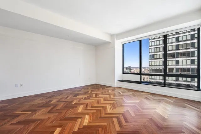 a view of an empty room with wooden floor