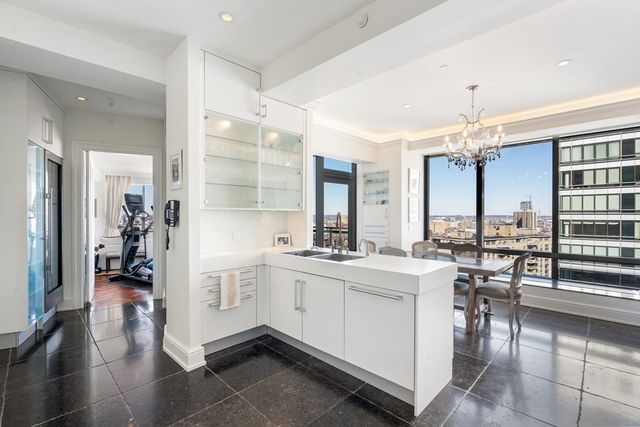 a large white kitchen with a large window and stainless steel appliances