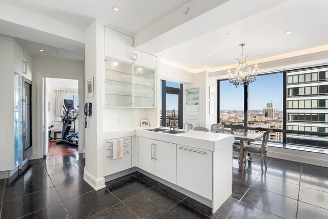 a large white kitchen with a large window and stainless steel appliances